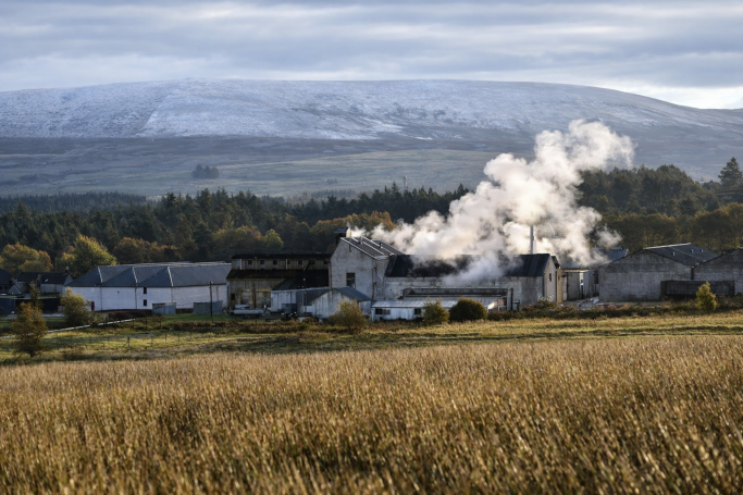 Tomatin Distillery with Snow-covered Mountains