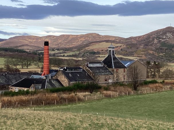 View across farmland towards Balblair Distillery in the Scottish Highlands